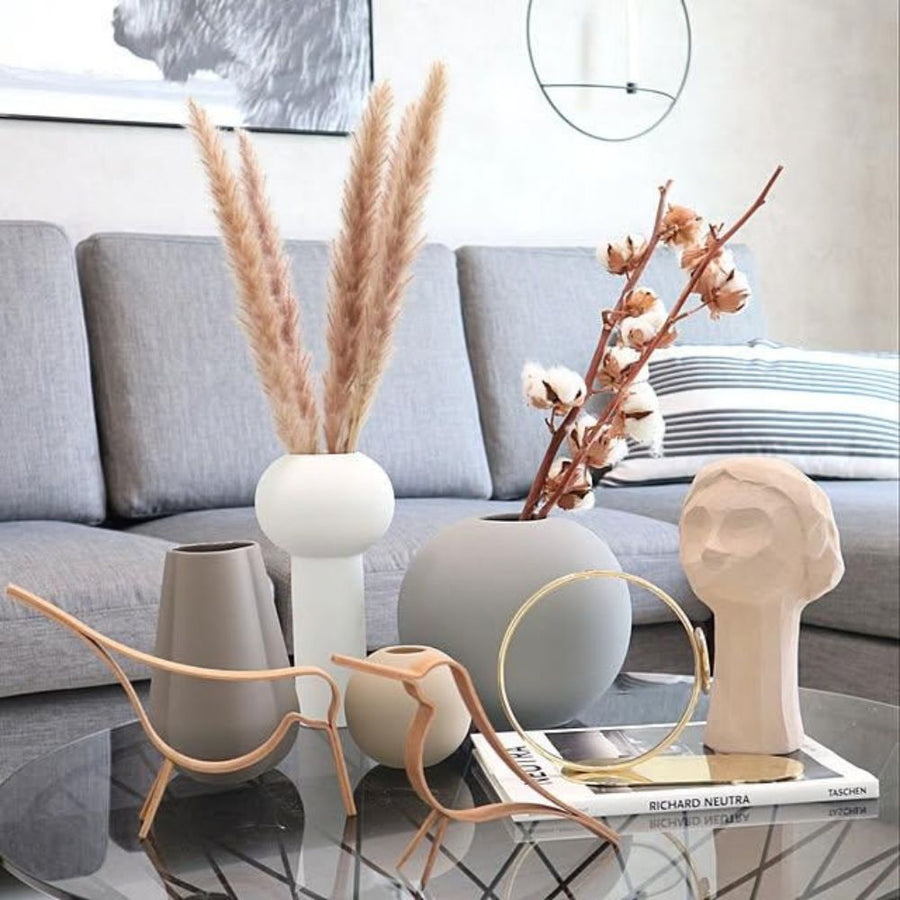 Neutral ceramic vases with pampas grass and cotton stems on coffee table